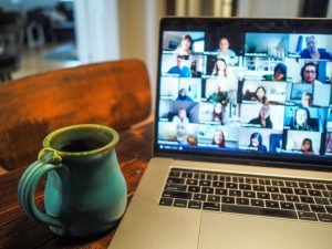This is photo of zoom call with a green cup of cofee.
