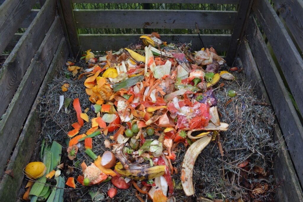 A black bin with compost in it. Compost consists of various colorful food waste.