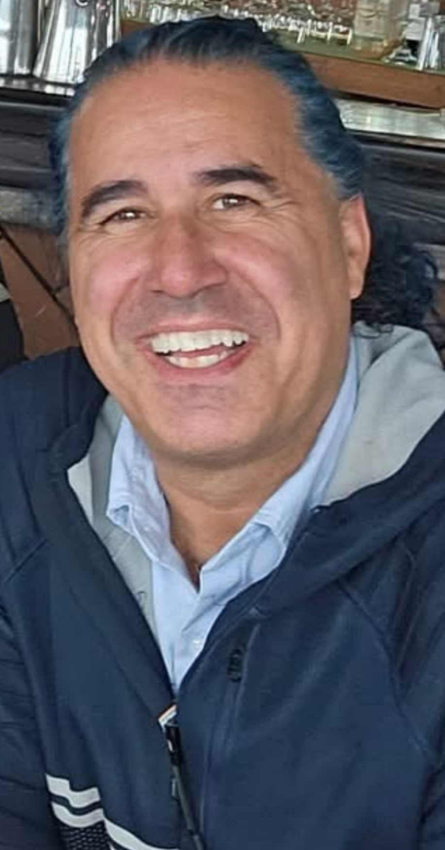 Our CEO and Founder picture in a blue jacket smiling.