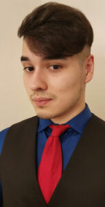 Picture showing a person with black suit and red tie