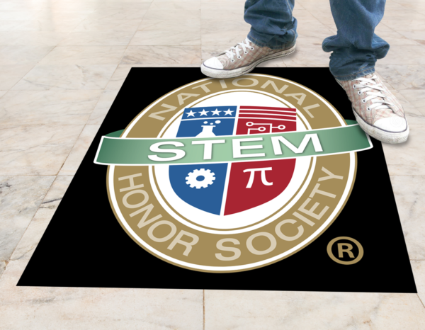 A person standing top of NSTEM poster which is present on floor.